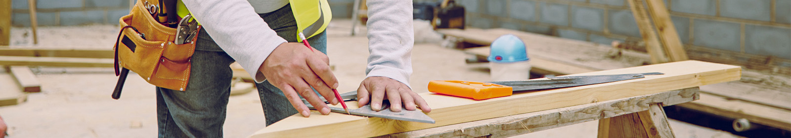 a builder measuring lumber