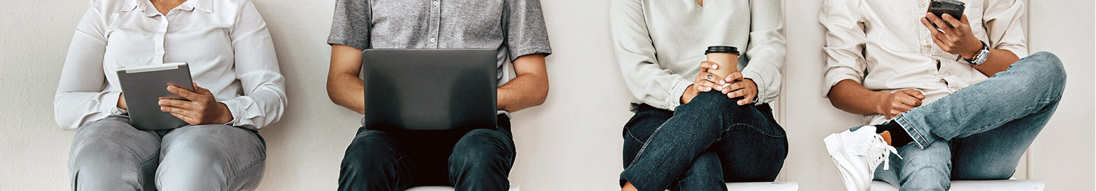 four people sitting holding objects in their hands